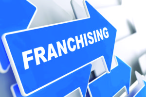 Franchising - Business Background. Blue Arrow with "Franchising" Slogan on a Grey Background. 3D Render.